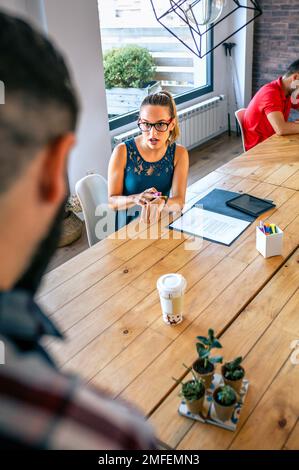 Ragazza manager arrabbiata discutere con l'uomo per essere arrivato in ritardo in ufficio Foto Stock