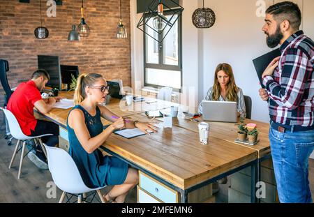 Ragazza manager arrabbiata discutere con l'uomo per essere arrivato in ritardo in ufficio Foto Stock