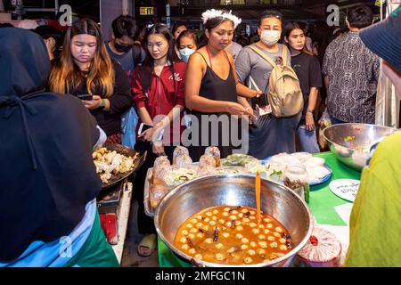 Fornitori di cibo e clienti al mercato di strada di notte a Pattaya, Thailandia Foto Stock