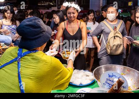 Fornitori di cibo e clienti al mercato di strada di notte a Pattaya, Thailandia Foto Stock