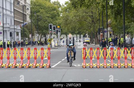 Londra, Inghilterra, Regno Unito. Famiglia in bicicletta in una strada chiusa al traffico per il funerale della regina Elisabetta II, 2022 Foto Stock