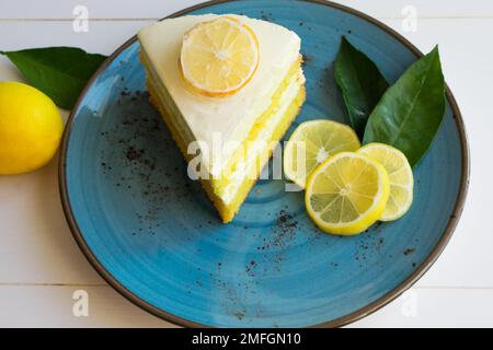 Un pezzo di torta di crema al limone su un piatto, presentazione di deliziose fette di torta ​​lemon, vista dall'alto. Foto Stock