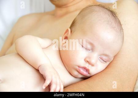 Scatto di una adorabile bambina che dorme sul petto di suo padre a casa Foto Stock