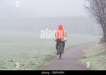 Eton, Windsor, Berkshire, Regno Unito. 25th gennaio 2023. Un ciclista in una mattina nebbiosa a Eton. Un avviso meteo di Met Office è stato emesso per un avvertimento giallo di nebbia fino alle 8am di questa mattina, tuttavia, la nebbia rimane come le temperature di congelamento. Credit: Maureen McLean/Alamy Live News Foto Stock