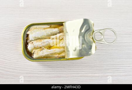 Shot ad angolo alto di deliziosa lattina di sardine su rustico tavolo di legno Foto Stock