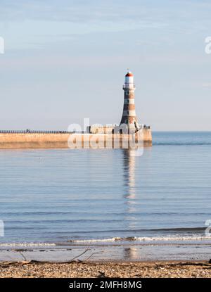 Meteo UK 24-1-2023 Faro di Roker riflesso in un mare liscio, Sunderland, Inghilterra, Regno Unito Foto Stock