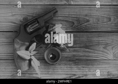 vintage still life con pistola e rosa in bianco e nero Foto Stock