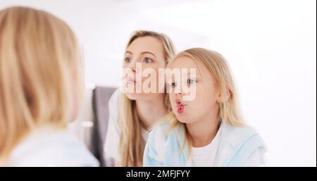 Facce felici e divertenti e madre con un bambino che guarda nello specchio mentre fa uno scherzo comico. Felicità, sorriso e giovane mamma che ha commedia divertimento con lei Foto Stock