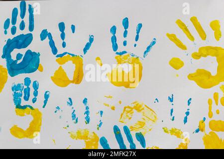 stampe luminose delle mani dei bambini da pittura sulla parete, sullo sfondo, sulla trama, sul formato orizzontale. Foto Stock