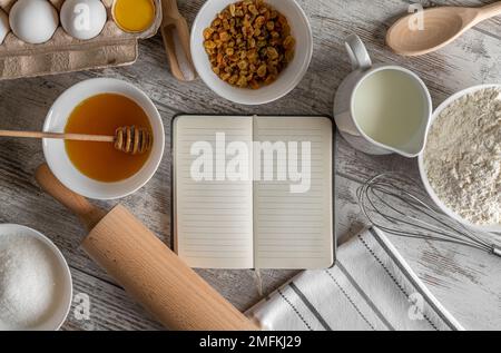 Blocco note e prodotti da forno sul tavolo. Foto Stock