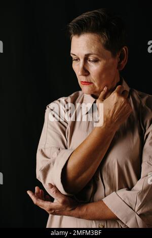 Drammatico ritratto di una donna matura. Tasto basso. Foto Stock