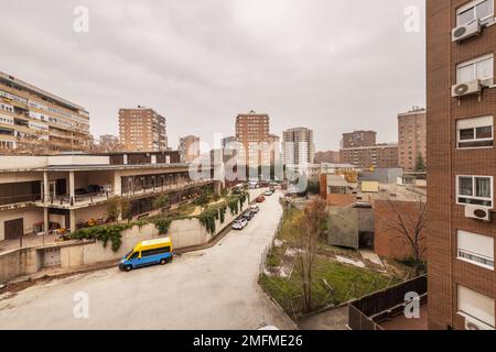 Un vicolo posteriore tra edifici residenziali con alcuni giardini in una giornata nuvolosa Foto Stock