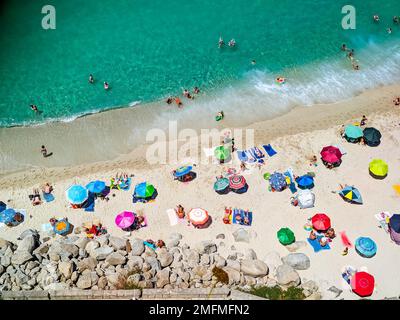 Spiagge italiane della Calabria visto dall'alto, i turisti visti riposare sotto ombrelloni colorati Foto Stock