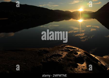 Splendido tramonto riflesso sul Meeting of the Waters nel Parco Nazionale di Killarney in inverno. Vista dal popolare punto panoramico in pietra sul Ring of Kerry Foto Stock