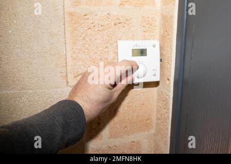 Termostato digitale intelligente per la casa uomo per regolare la temperatura del riscaldamento nella parete della stanza Foto Stock