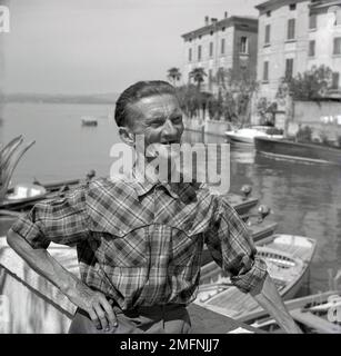 1950s, storico, estivo e uno spgiustamente locale che si trova al porto dell'isola d'Ischia, forse un pescatore. La pittoresca isola si trova nel Golfo di Napoli. Foto Stock