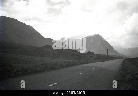 1951, strada storica per Glen Coe, Highlands scozzesi, Scozia, Regno Unito. Un glen di origine vulcanica, l'area dell'Highland Occidentale è famosa per il suo paesaggio selvaggio e bello e per i suoi passi di montagna. Foto Stock