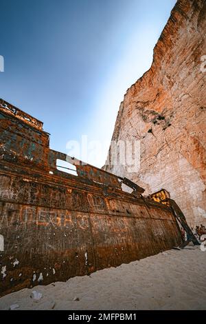 Fantastica vista del vecchio relitto arrugginito sulla spiaggia di Navagio (Smugglers Cove) sull'isola di Zante in Grecia, circondata da alte scogliere Foto Stock