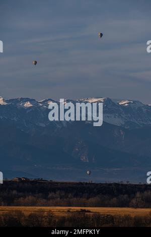Uno scatto verticale di due mongolfiere visto galleggiare nel cielo con le montagne nella parte posteriore Foto Stock