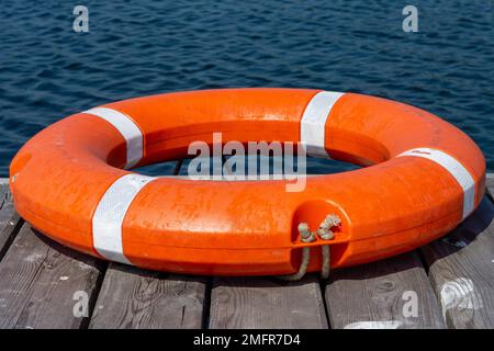 La lifboa si trova su un molo di legno. Il concetto di risparmio annegando sull'acqua. Foto Stock