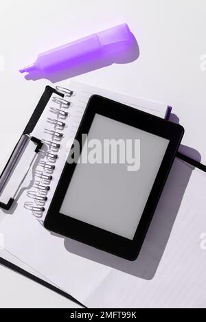 Schermo del tablet con idee importanti e nota appiccicata sulla scrivania con notebook e marcatore. Cellulare con informazioni Cruziali e Memo Foto Stock