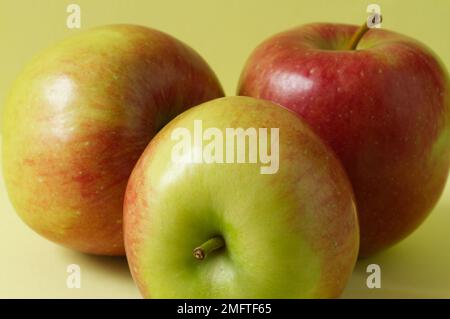 Primo piano di tre mele Braeburn su sfondo piano Foto Stock