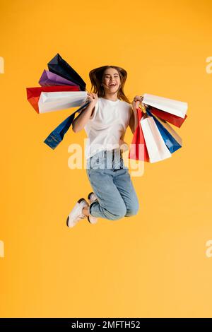 ritratto giovane femmina con shopping bag salto Foto Stock