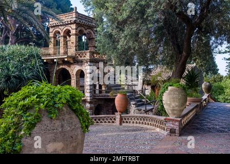 Edifici fantasiosi e splendide piantagioni nel Parco Florence Trevelyan, una delle principali attrazioni della destinazione turistica di Taormina. Foto Stock