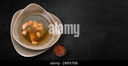 Orecchie di trota con erbe e salsa piccante, su fondo grigio di cemento Foto Stock