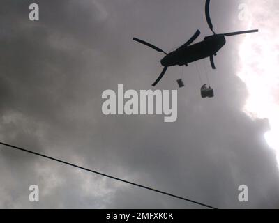 Velivoli - Sand Baggers - 26-HK-57-137. Parte inferiore dell'elicottero Chinook che vola con una borsa di sabbia. Uragano Katrina Foto Stock