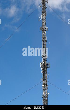 Swindon, Inghilterra - Aoril 2022: Trasittori e attennae per comunicazioni di telefonia mobile collegate ad un palo televisivo Foto Stock