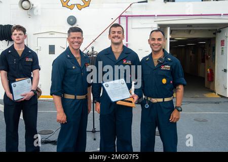 MARE DELLE FILIPPINE (20 agosto 2022) – Capitan Jeffrey Feinberg, comandante della USNS Mercy (T-AH 19), a sinistra, E il capo maggiore del comando Manuel Valle, a destra, premia Hospitalman tal Zvik, di El Paso, Texas, Center, Sailor del mese di luglio a bordo della nave militare dell'ospedale Sealift Command USNS Mercy (T-AH 19) in riconoscimento degli sforzi di Zvik durante il Pacific Partnership 2022. Ora nel suo 17th° anno, Pacific Partnership è la più grande missione multinazionale annuale di assistenza umanitaria e di preparazione alle catastrofi condotta nell'Indo-Pacifico. Foto Stock