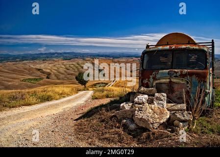 Paesaggio rurale delle Crete Senesi, Toscana, Italia con un camion distrutto Foto Stock