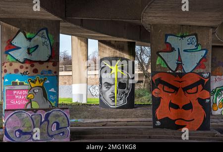 Graffiti ha coperto le colonne sotto l'autostrada M8 a Glasgow, Scozia. Foto Stock