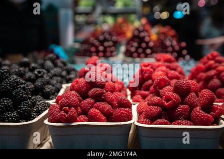 Una confezione di lamponi che vendono in un mercato locale della frutta. Foto Stock