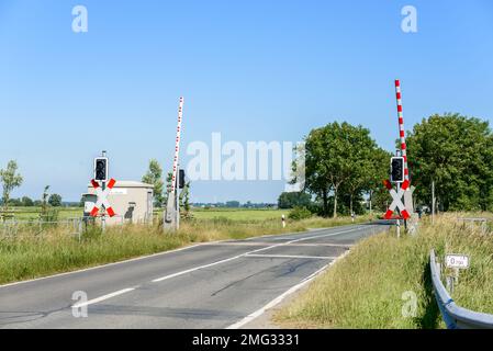 Attraversamento di livello con barriere alzate per consentire al traffico di passare in sicurezza nelle campagne della Germania in una chiara giornata estiva Foto Stock
