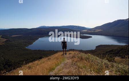 Giovane escursionista maschio godendo del panorama alpino del Lago Rotoiti dal Monte Robert Trail nel Parco Nazionale dei Laghi di Saint Arnaud Nelson Tasman Foto Stock