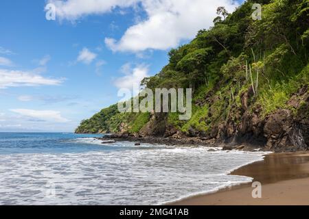 Le onde si lavano sulla riva della vivace costa verde lungo il Golfo di Papagayo, Playas del Coco, Provincia di Guanacaste nella Costa Rica nord-occidentale. Foto Stock