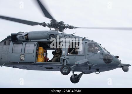 220822-N-VJ326-1341 MARE DELLE FILIPPINE (22 agosto 2022) – un elicottero MH-60s Sea Hawk assegnato a Helicopter Sea Combat Squadron (HSC) 23 vola sopra il vettore d'assalto anfibio USS Tripoli (LHA 7), 22 2022 agosto. Tripoli opera nell'area delle operazioni della flotta 7th degli Stati Uniti per migliorare l'interoperabilità con alleati e partner e fungere da pronta forza di risposta per difendere la pace e mantenere la stabilità nella regione dell'Indo-Pacifico. Foto Stock