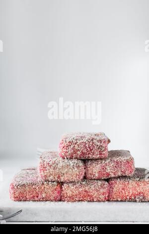 Lamponi rosa su vassoio di marmo, lamponi australiani, torta ricoperta di noci di cocco essiccate Foto Stock