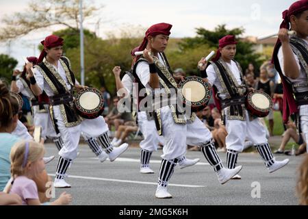 I batteristi SHIME-daiko con Jaagaru EISA Group si esibiscono in una marcia EISA su Camp Foster, Okinawa, Giappone, 21 agosto 2022. Originario di Okinawa, l'EISA iniziò come una danza tradizionale eseguita dai monaci buddisti giapponesi per onorare gli spiriti dei loro antenati. Da allora, EISA si è evoluta in una forma di intrattenimento moderno comunemente eseguito durante il Festival di Obon nei mesi estivi. Foto Stock