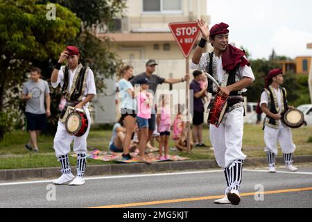 I batteristi SHIME-daiko con Jaagaru EISA Group si esibiscono in una marcia EISA su Camp Foster, Okinawa, Giappone, 21 agosto 2022. Originario di Okinawa, l'EISA iniziò come una danza tradizionale eseguita dai monaci buddisti giapponesi per onorare gli spiriti dei loro antenati. Da allora, EISA si è evoluta in una forma di intrattenimento moderno comunemente eseguito durante il Festival di Obon nei mesi estivi. Foto Stock