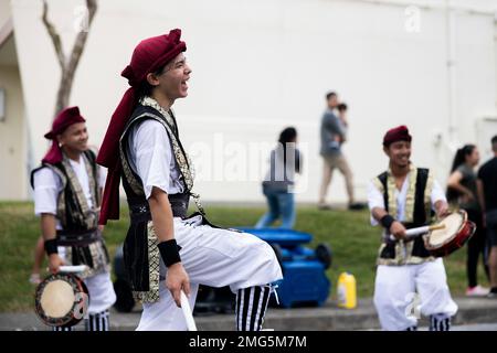 I batteristi SHIME-daiko con Jaagaru EISA Group si esibiscono in una marcia EISA su Camp Foster, Okinawa, Giappone, 21 agosto 2022. Originario di Okinawa, l'EISA iniziò come una danza tradizionale eseguita dai monaci buddisti giapponesi per onorare gli spiriti dei loro antenati. Da allora, EISA si è evoluta in una forma di intrattenimento moderno comunemente eseguito durante il Festival di Obon nei mesi estivi. Foto Stock