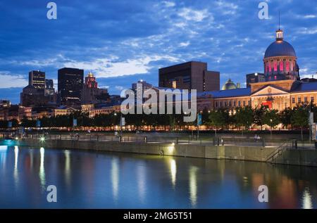 Porto vecchio di Montreal con il mercato di Bonsecours e lo skyline illuminato al crepuscolo d'estate, Quebec, Canada. Foto Stock