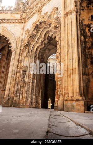 Batalha, Portogallo - 23 agosto 2022: Vista dal basso del bellissimo portale di accesso Manueline alle cappelle imperfette nel monastero di Batalha Foto Stock