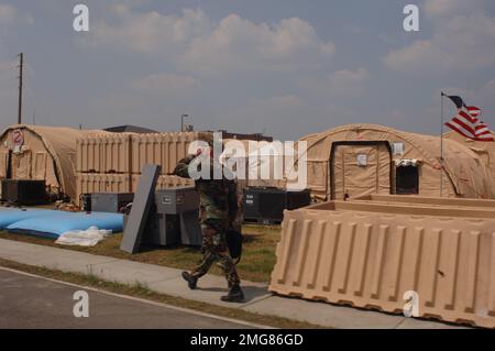 Ausili alle operazioni di navigazione - 26-HK-63-48. personale militare che cammina oltre la tenda città. Uragano Katrina Foto Stock