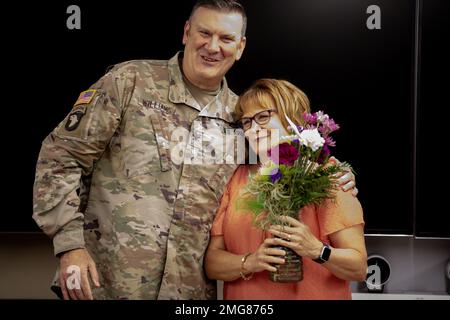 L'assistente esecutivo della Guardia Nazionale dell'Illinois Kelly Wood è stato dato un bouquet di fiori dal Colonnello Lenny Williams, capo di stato maggiore della Guardia Nazionale dell'Illinois agosto 23, 2022 alla sede della forza congiunta della Guardia Nazionale dell'Illinois a Camp Lincoln in occasione del 35th° anniversario dell'impiego della signora Wood presso la Guardia Nazionale dell'Illinois. Williams per la prima volta incontrò Kelly quando era un sergente. La riconobbe per la sua continua dedizione alla Guardia Nazionale dell'Illinois dal 1987. Foto Stock