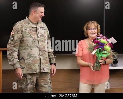 L'assistente esecutivo della Guardia Nazionale dell'Illinois Kelly Wood è stato dato un bouquet di fiori dal Colonnello Lenny Williams, capo di stato maggiore della Guardia Nazionale dell'Illinois agosto 23, 2022 alla sede della forza congiunta della Guardia Nazionale dell'Illinois a Camp Lincoln in occasione del suo 35th° anniversario di lavoro per la Guardia Nazionale dell'Illinois. Williams per la prima volta incontrò Kelly quando era un sergente. La riconobbe per la sua continua dedizione alla Guardia Nazionale dell'Illinois dal 1987. Foto Stock