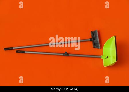 Scopa per pulizia con paletta verde su sfondo colorato Foto Stock