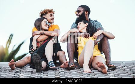 Rilassati, felice e coppia di amici sul tetto per la comunicazione, la felicità e l'estate a Miami. Conversazione, diversità e gruppo di uomini parlanti e. Foto Stock